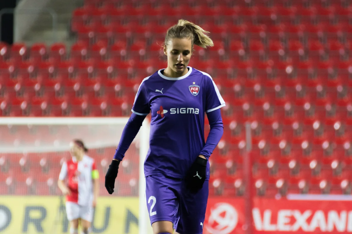 Kvinnlig fotbollsförsvarare i landslagströja på en fotbollsplan