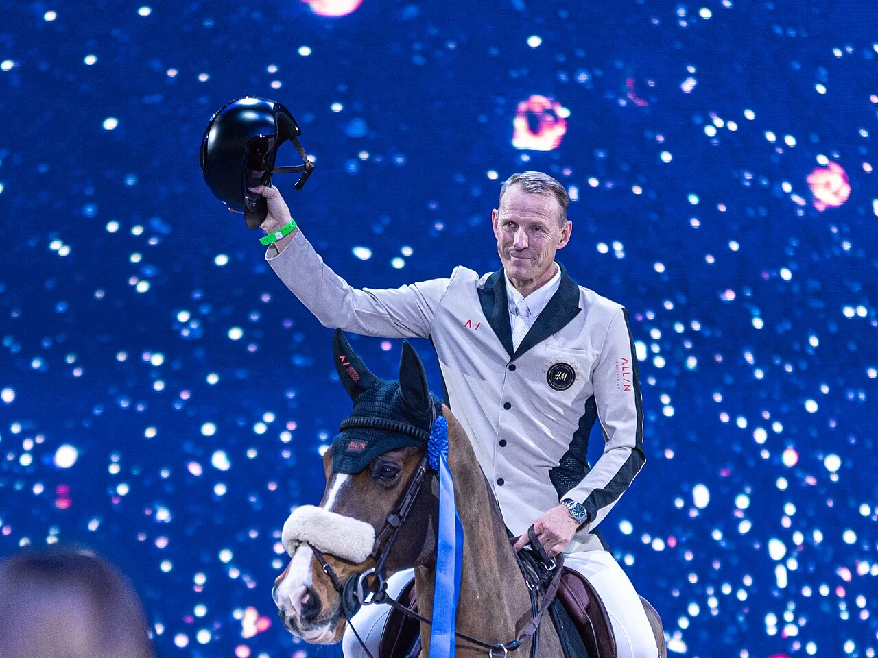 Peder Fredricson lyfter hjälmen mot publiken från hästryggen under prisutdelningen på Sweden International Horse Show 2024